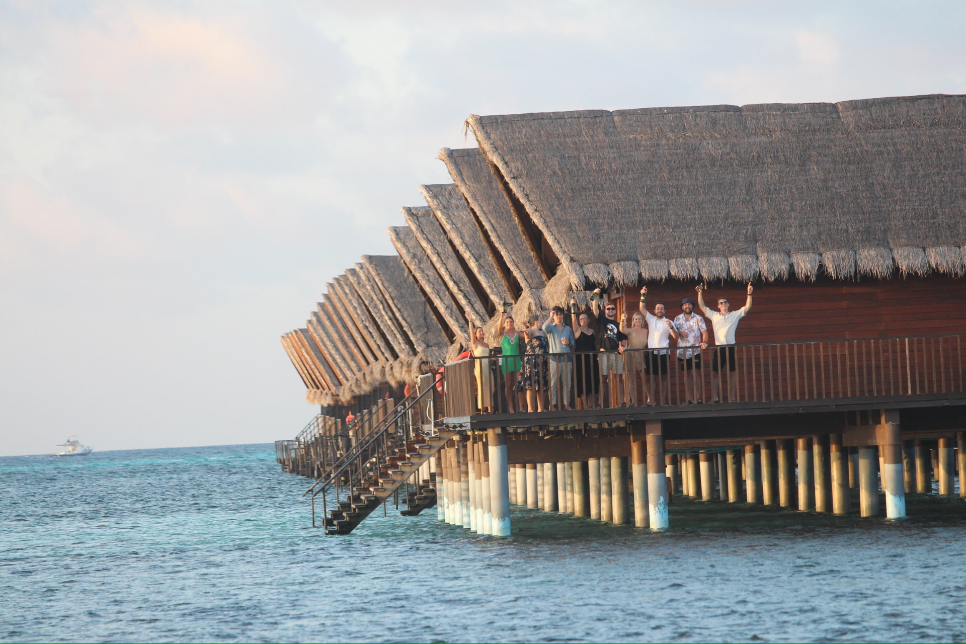 Retreat group celebrating on an overwater villa deck in the Maldives